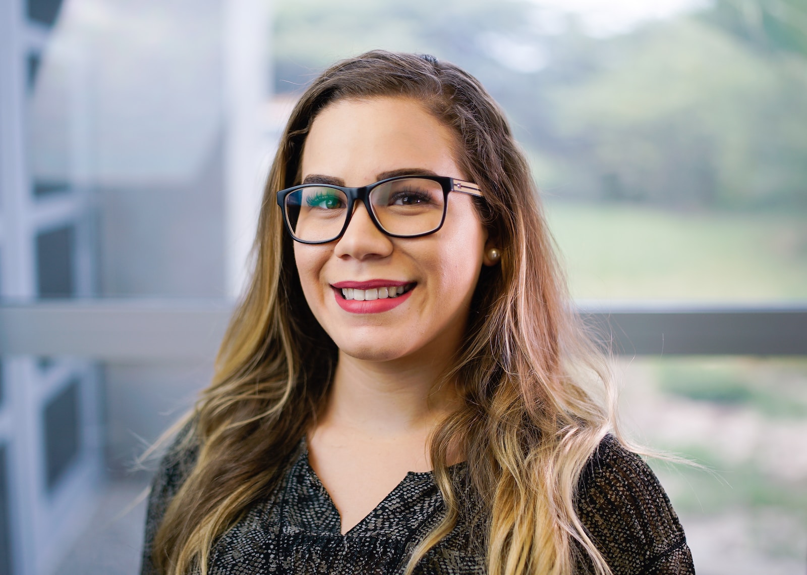 a woman with glasses smiling for the camera